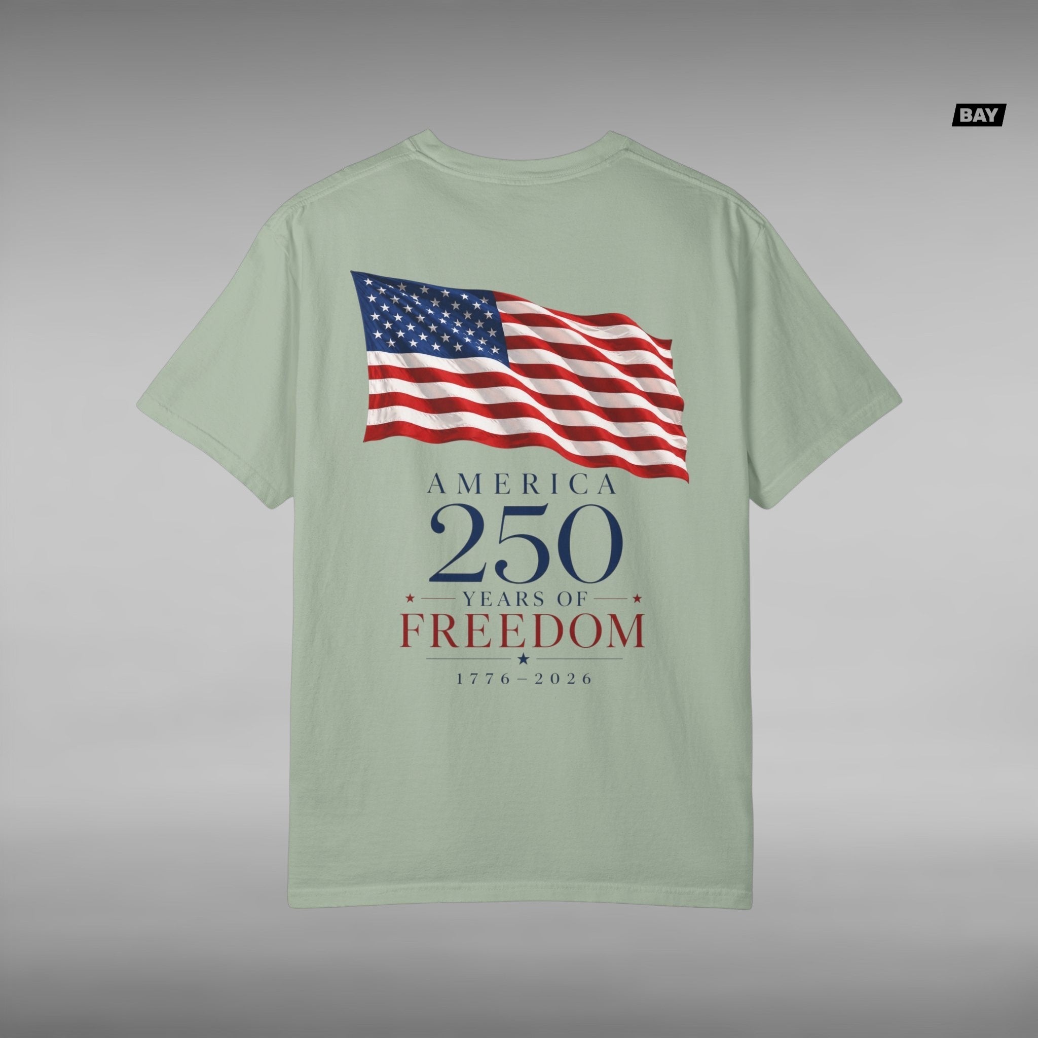Move Vibe sage green garment-dyed cotton t-shirt featuring a back graphic of a waving American flag and 250th text.